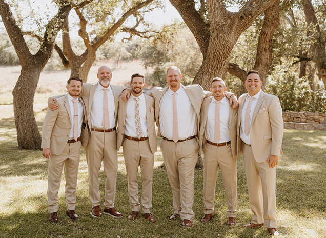 Groom and groomsmen smiling together before the ceremony at The Addison Grove in Dripping Springs, Texas, photographed by Grace J Photo, a Texas Hill Country wedding photographer.