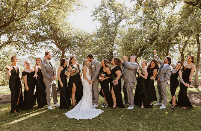 Wedding party cheering for bride and groom during portraits at Canyonwood Ridge in Dripping Springs, Texas wedding