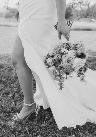 Black and white photo of bride’s bouquet during wedding at Camp Hideaway in Fredericksburg, Texas