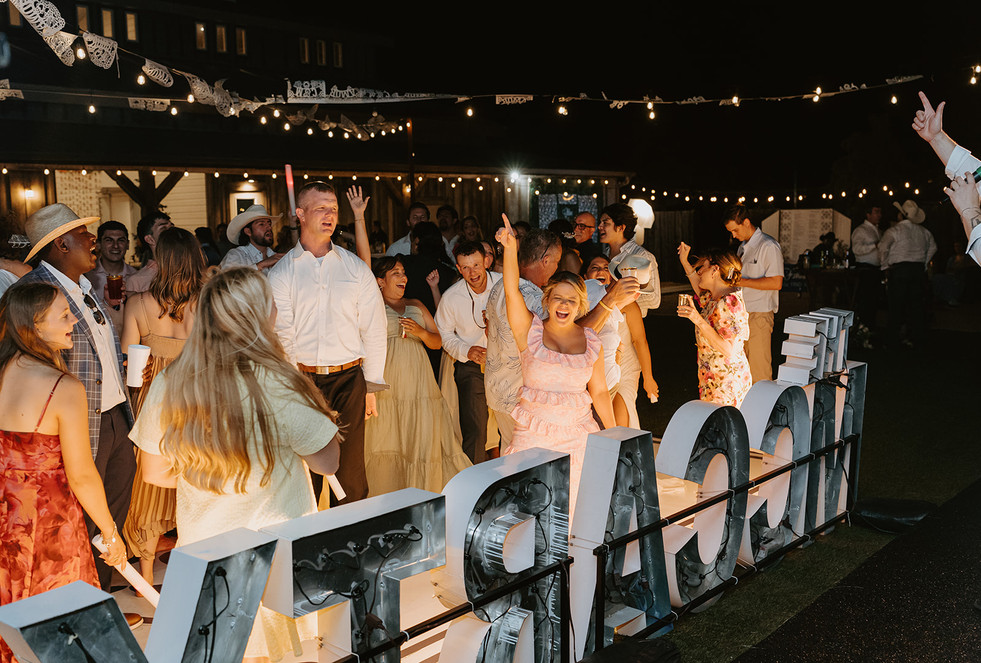 Friends dancing together during reception at Camp Hideaway in Fredericksburg, Texas wedding