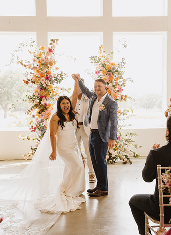 Bride and groom cheering together after ceremony at Camp Hideaway in Fredericksburg, Texas wedding