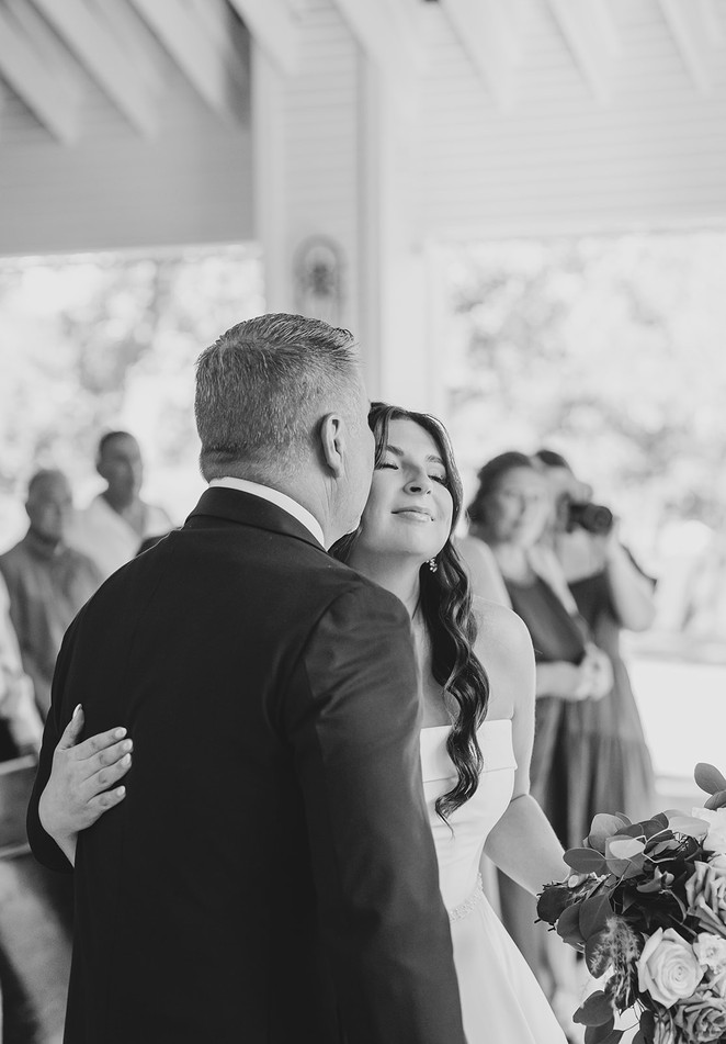 Mother smiling proudly at the bride during the wedding ceremony at The Chandelier of Gruene.