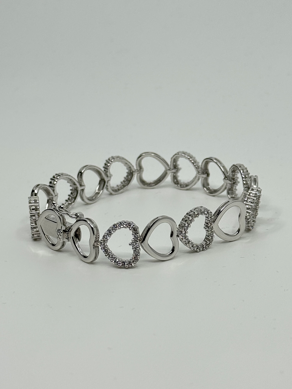 Pulsera de plata con corazones entrelazados, brillante y elegante.