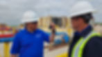 Two people inspecting a test tube at an oil and gas facility