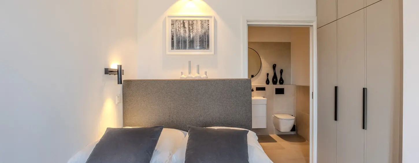 Schlafzimmer mit Einbauschrank und En-Suite-Bad in einem vollständig möblierten Studio M Apartment
