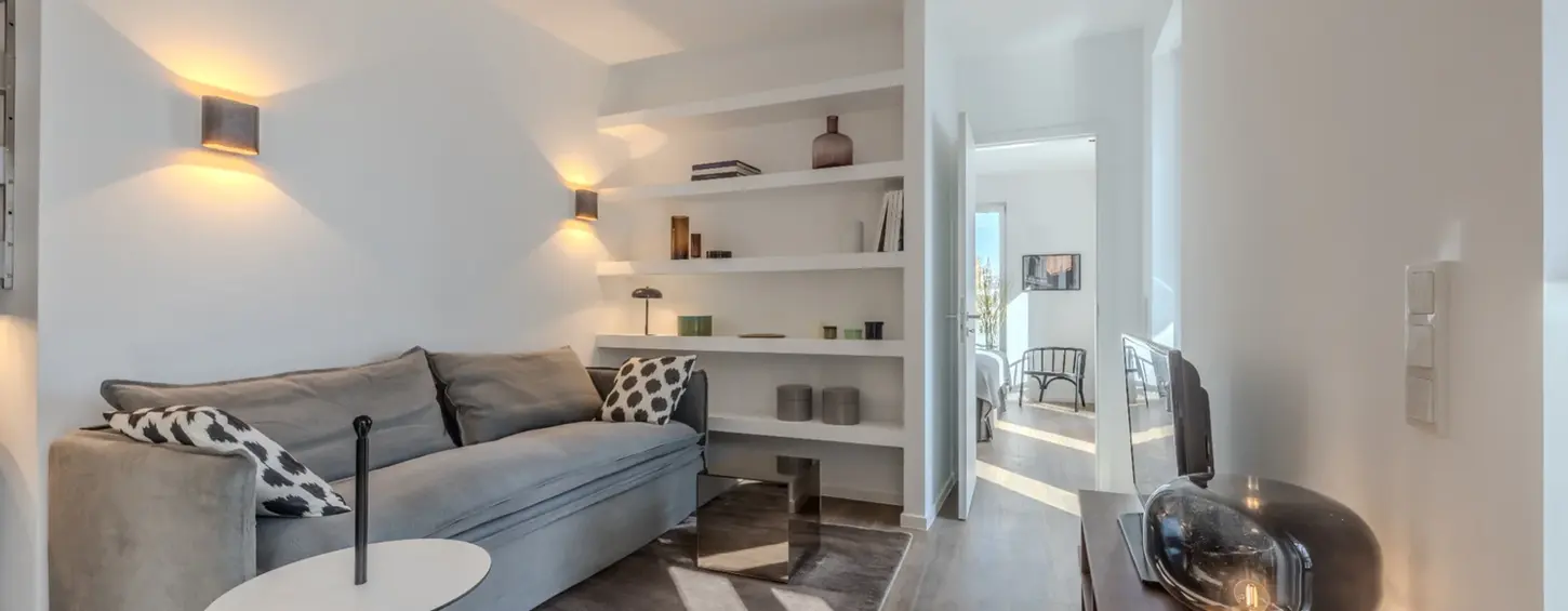 Wohnzimmer mit Sofa und Blick in den Essbereich in einem vollständig möblierten Apartment XL