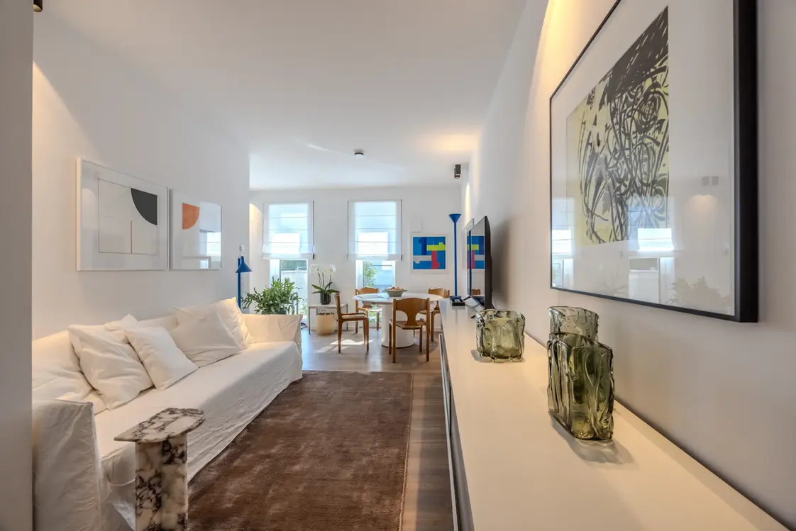 Living room with white sofa, sideboard and modern art in a fully furnished apartment, Frankfurt