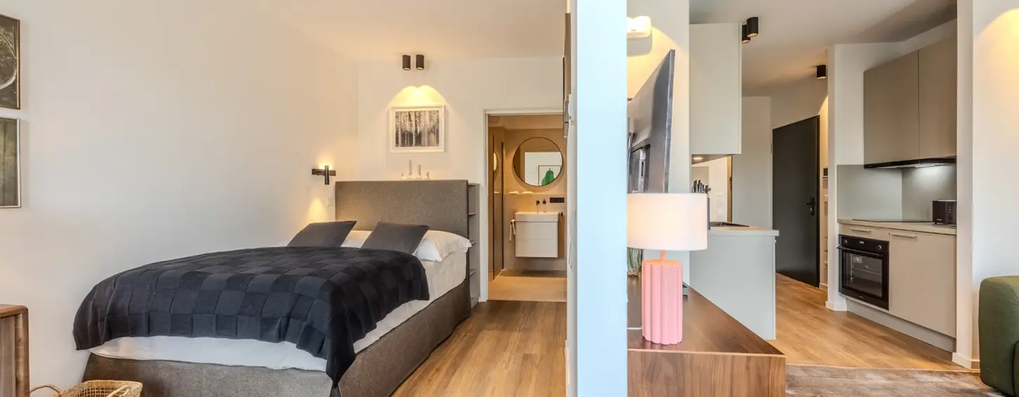 Schlafzimmer und Küche im offenen Grundriss eines Studio M Apartments, Frankfurt Sachsenhausen