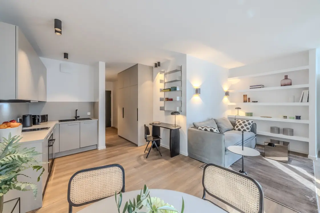 Long open-plan layout with kitchen, workspace and living area in a fully furnished Apartment XL