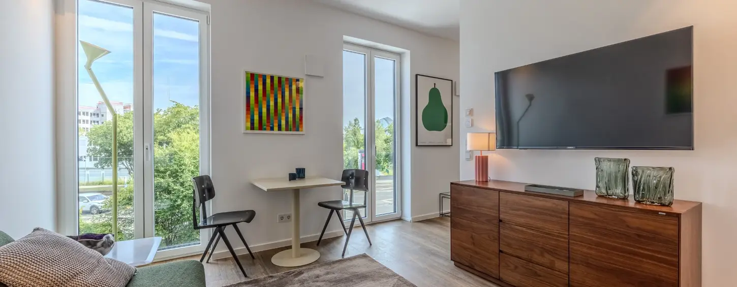 Komfortabler Wohnbereich mit Sofa, TV und Essecke in einem vollständig möblierten Apartment, Frankfurt