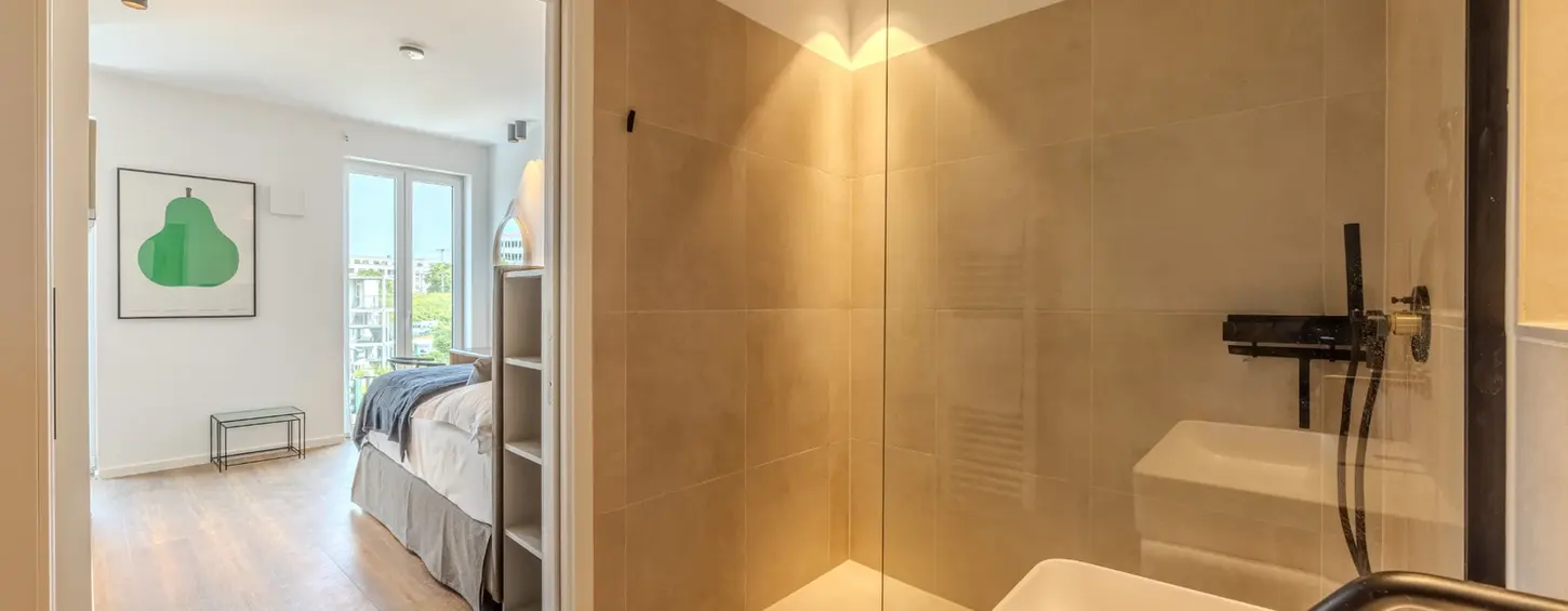 Modernes Badezimmer mit bodengleicher Dusche in einem vollständig möblierten Apartment in Frankfurt Sachsenhausen