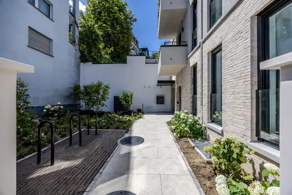 Landscaped courtyard path leading to the Main Casa building entrance in Sachsenhausen