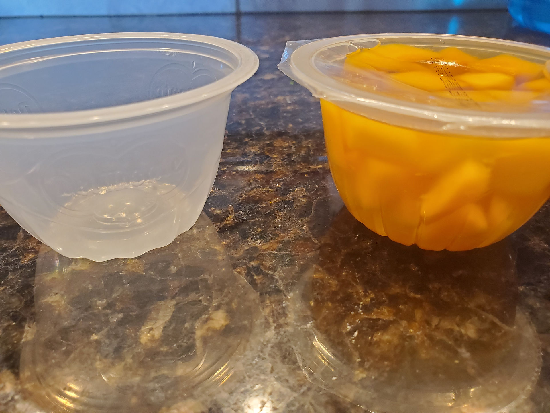 Comparison of an empty fruit cup container and a full one with diced peaches for meal prep hacks.