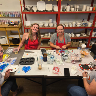 Friends Heather and Denise smiling together while working on mosaic projects at The Hot Spot craft studio in South Lake Tahoe.