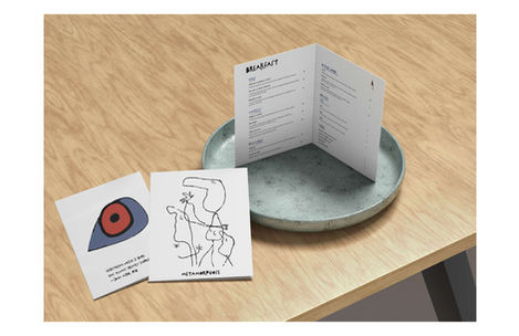 Open breakfast menu on table with art cards
