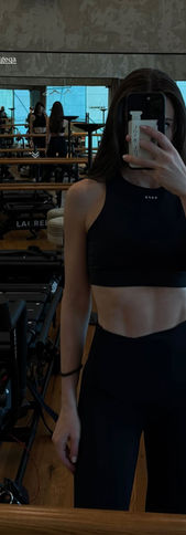 An instructor taking a selfie of herself by the mirror after her class wraps up at the Lodge Megaformer in Doha