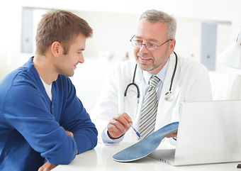 doctor holding orthotic insole consulting with a man
