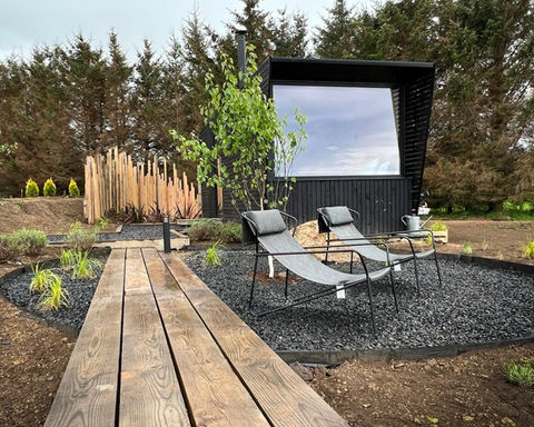 cabin self catering naturalistic planting. garden design board walk gravel garden ornamental grasses