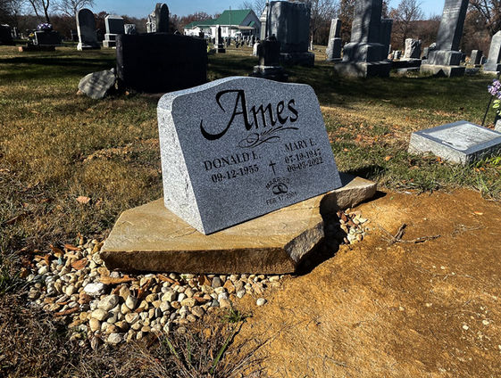polished granite headstone with a natural stone base 