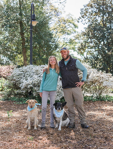 Sam and Michelle, owners of Walk N Wag pose with their dogs at the Statehouse grounds in Columbia, South Carolina