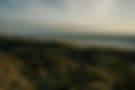De foto toont een zacht verlicht duinlandschap, symbool voor tijdloze schoonheid, dynamiek en rust—waarden die wij vertalen naar strategie en visualisatie.