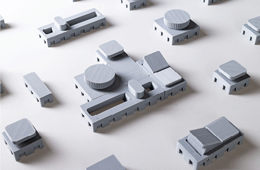 GIF of two alternating photographs. First photo is of the physical actuators. The second photo is of the actuators flipped upside down in their spots to show the computer vision markers underneath.