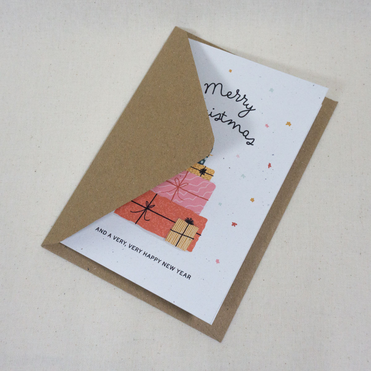 Christmas card with hand-drawn stack of wrapped presents reading Merry Christmas with kraft brown envelope