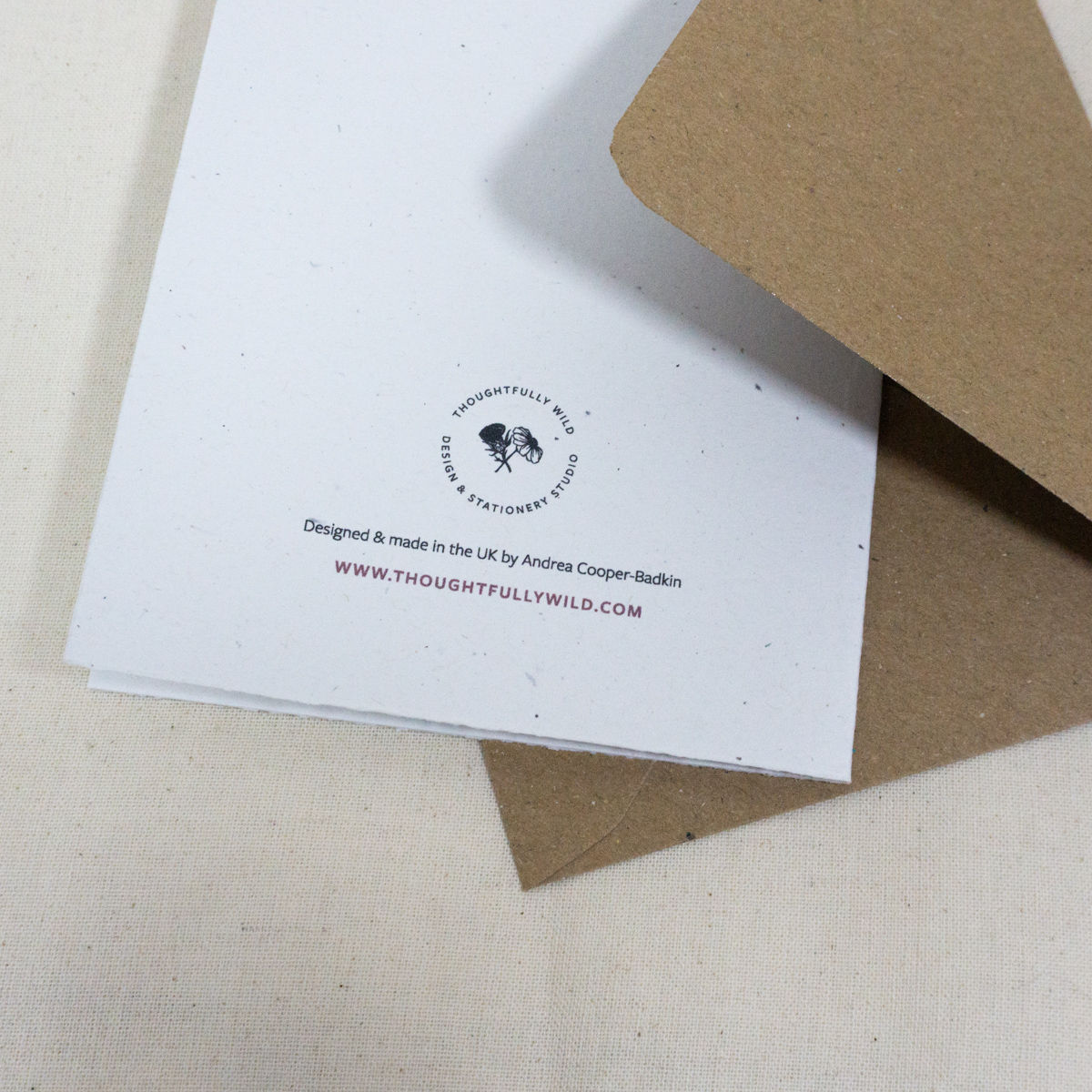Back of Christmas card showing Thoughtfully Wild logo with kraft brown envelope