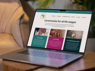 Reena Joy new website shown on a mockup of a laptop sat on a wooden table