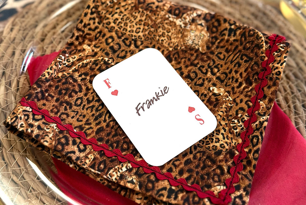 Playing card style table place name styled with a leopard print napkin and clear charger plate