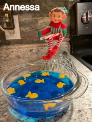Elf figurine jumping over blue gelatin with fish-shaped crackers inside
