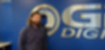 Man smiles in front of the logo,