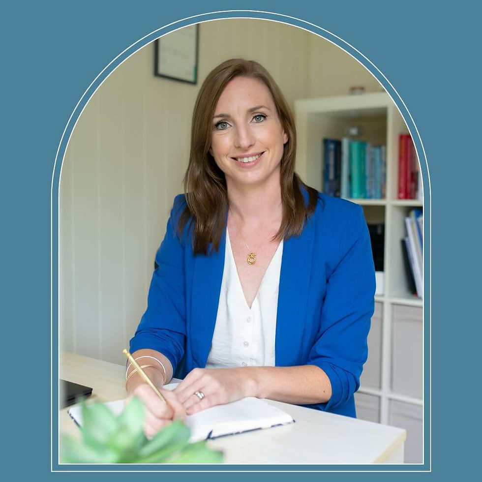 happy woman with blue jacketand white top, she has brown hair and a pen in her hand