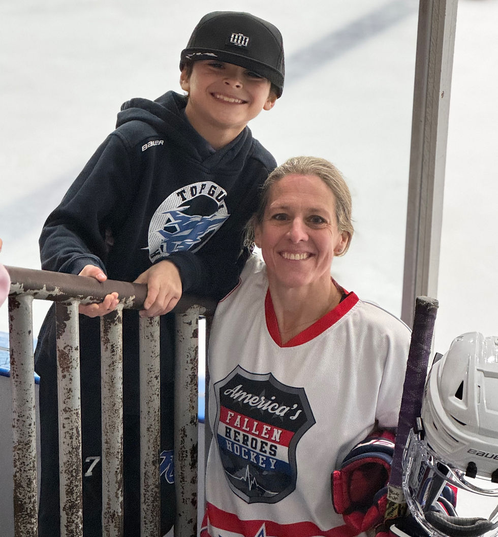 Woman in Fallen Heroes hockey jersey with boy at rink