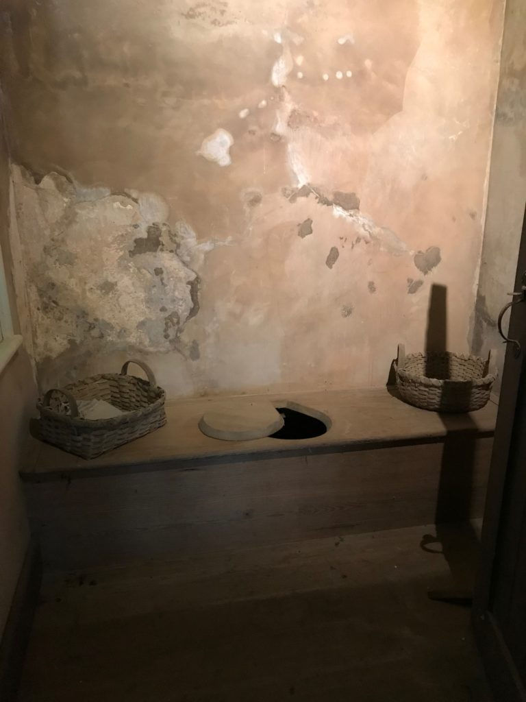 One of Monticello's three privies; the walls are limewashed and there sits baskets of napkins to use.