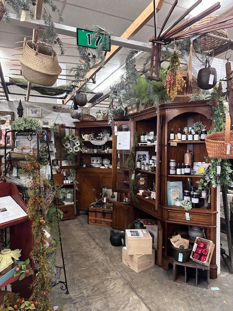 A photo of more of the cabinets, which carry jams, jellies, essential oils, candles, herb sachets, and antiques.