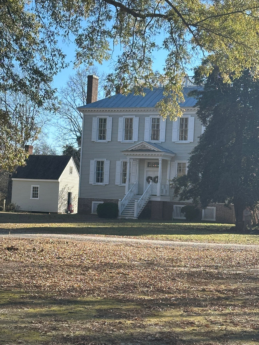 The backside of the Historic Hope House, decorated in Christmas wreaths and framed by trees above and to the right of it. On the left side is the fully preserved kitchen.