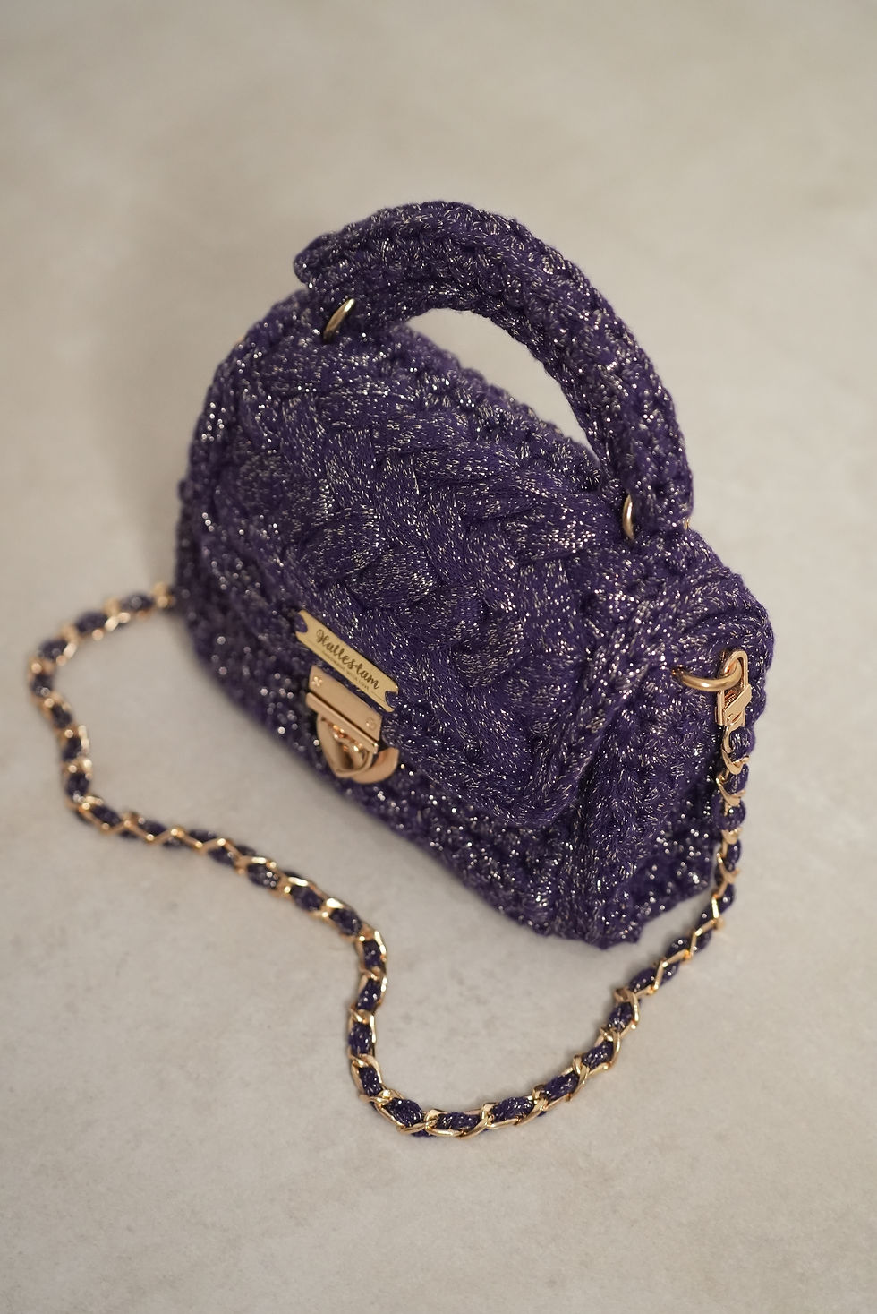 Shimmering puff purple color gold details displayed from the side Hallestam Design