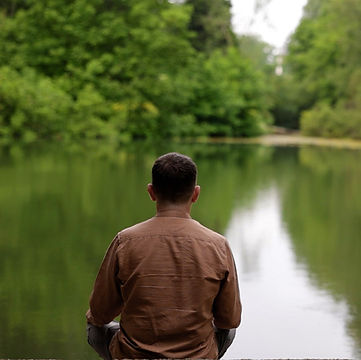 Man meditating on the board of a lake