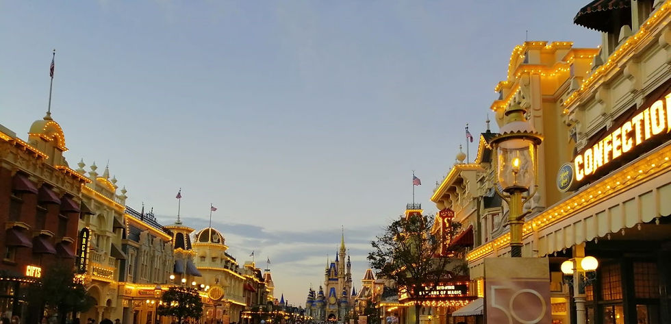 La maravillosa vista de Main Street U.S.A. al caer la tarde con todos los edificios iluminados y el castillo de fondo