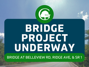 Sign reading "Bridge Project Underway" with a green logo. Location details: Belleview Rd, Ridge Ave, SR 1. Clear sky background.