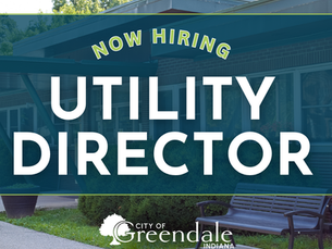 Now Hiring Utility Director sign over a City of Greendale, Indiana building with bench and trees.