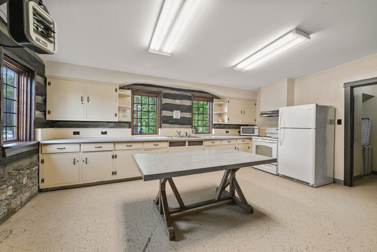 Greendale Cabin kitchen with fridge and tables.
