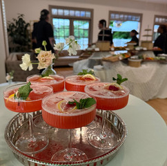 A tiered silver tray of pink strawberry-lemon cocktails garnished with fresh mint and lemon slices, served during a private confirmation party catered by Founding Farmers Co. Catering & Events in the DC metro area.