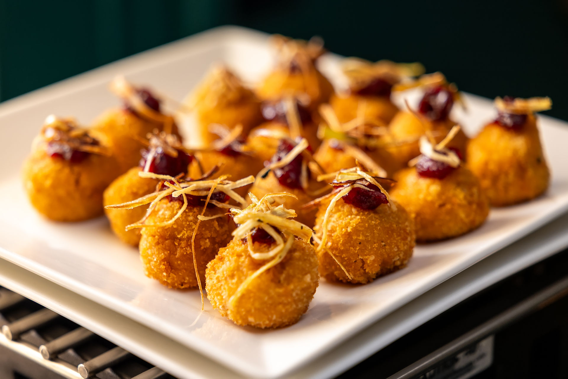 Golden fried appetizer bites topped with cranberry and crispy garnish served at a Founding Farmers Co. catered event at Willowood Washington