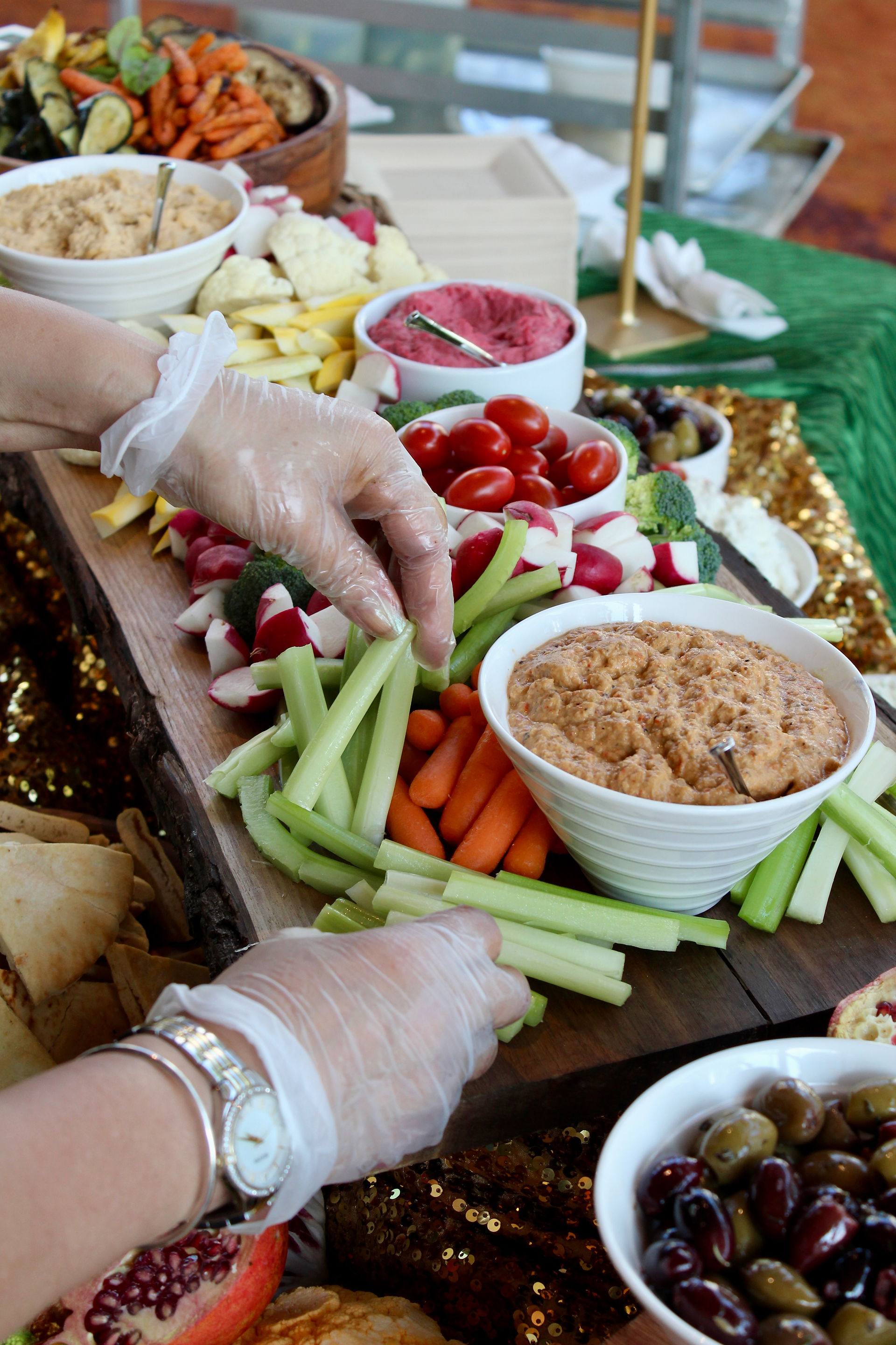 Guest serving vegetables and dips from the Summer Harvest Crudité display, featuring beet hummus, green goddess dip, and fresh vegetables at the RAMMYS awards reception