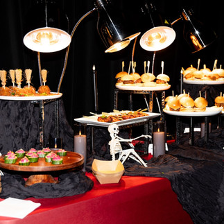 Curated catering tablescape with various Halloween-themed food options.