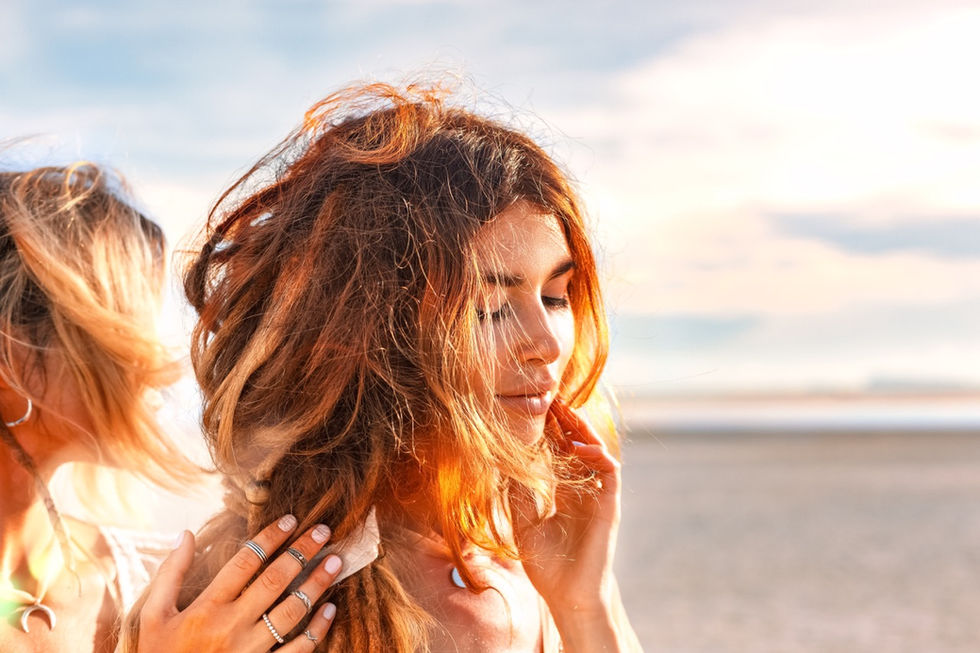 Frau mit wehendem Haar, Sonnenuntergang am Strand, sanfte, warme Beleuchtung, entspannte Stimmung