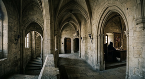 Vista interna detalhada das antigas muralhas de pedra góticas do Palácio dos Papas em Avignon, servindo de metáfora visual para discutir as estruturas de poder e o absolutismo judicial.