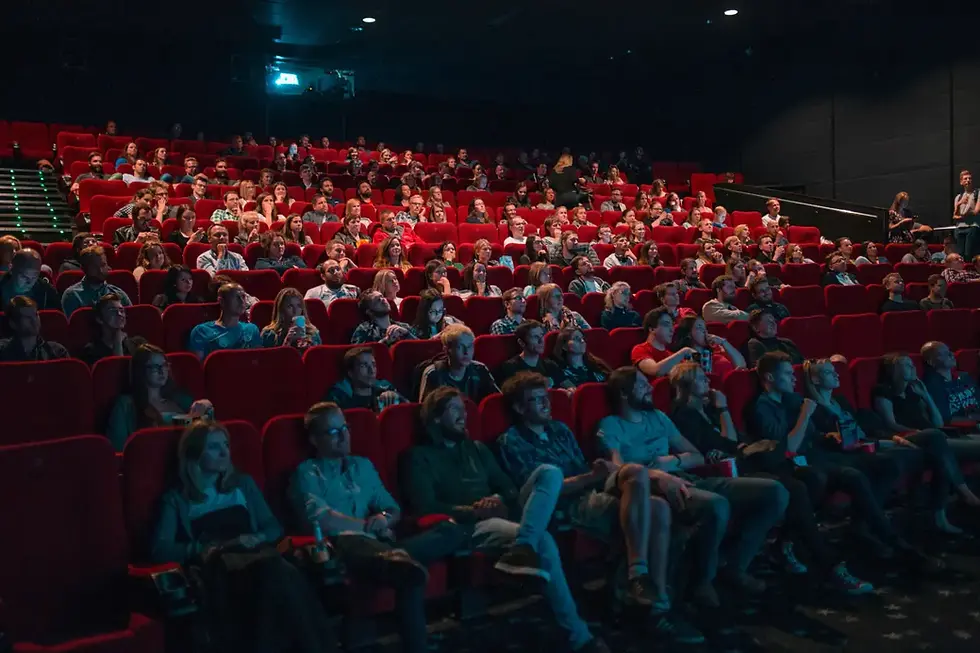 Audience watching movie in packed movie theatre